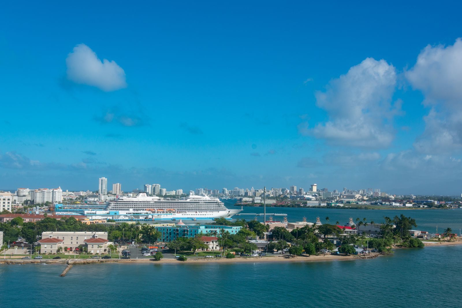 Aerial view of a cruise ship moored at a busy coastal port city, the scene at the busiest cruise ports in the US