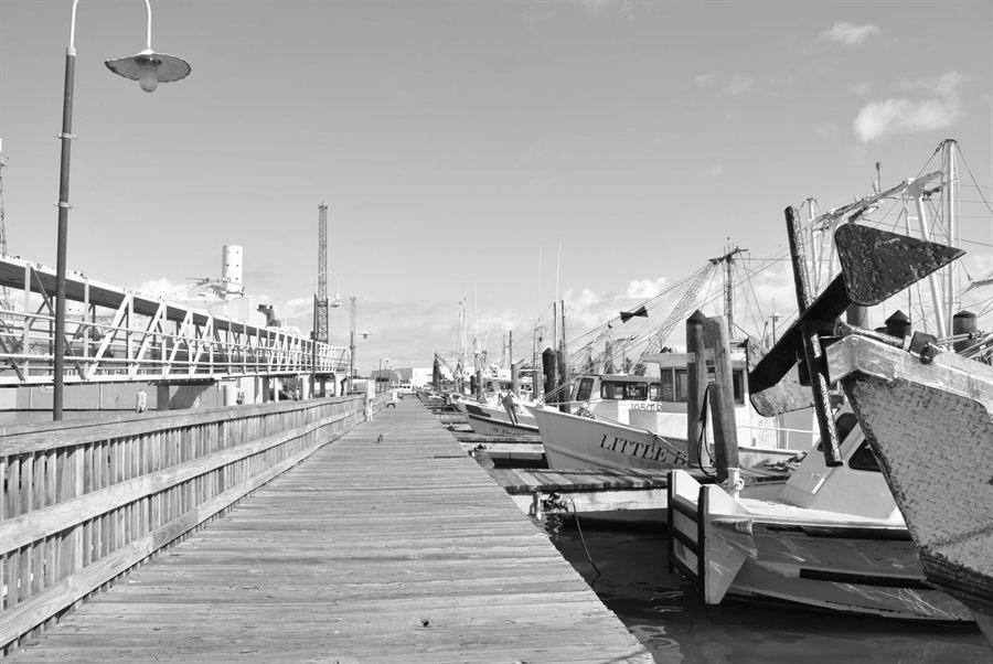 Black-and-white view of boats and a pier on the Galveston waterfront